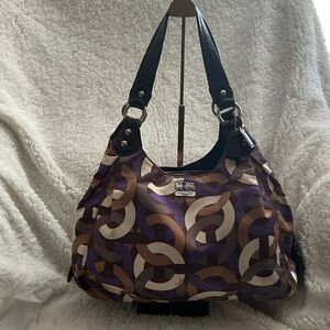 Coach Madison Maggie hobo bag in a purple and beige op art chainlink pattern.
